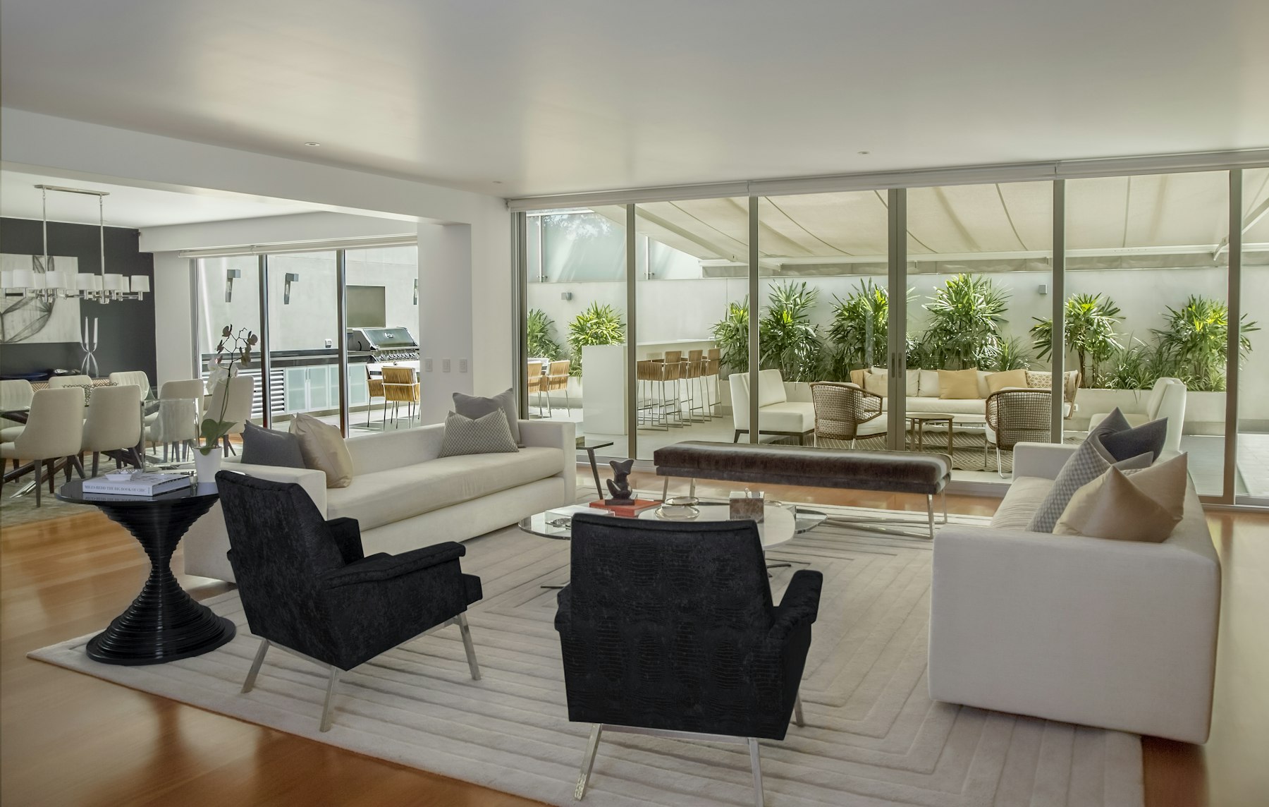 Wide open living room with a full wall of sliding glass opening onto a covered terrace