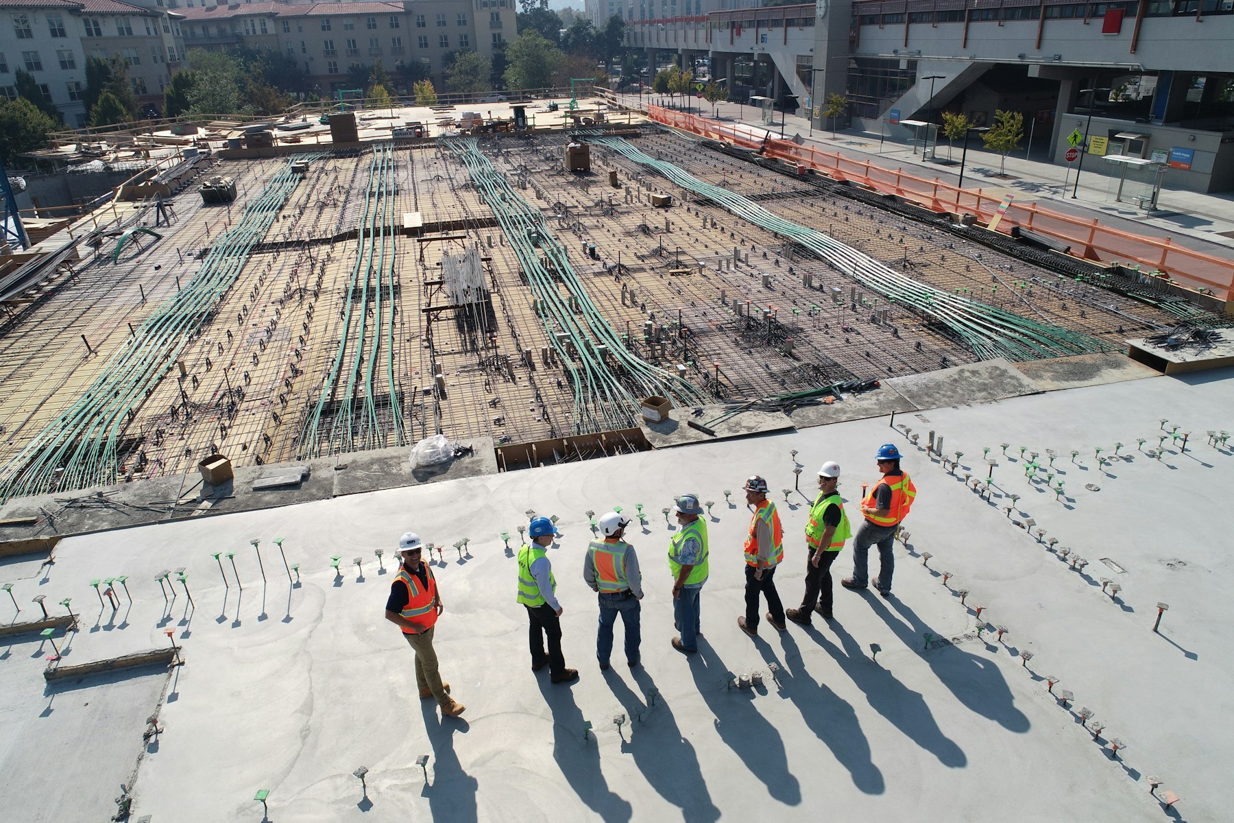 Crew standing on a freshly formed concrete deck above a reinforced slab pour