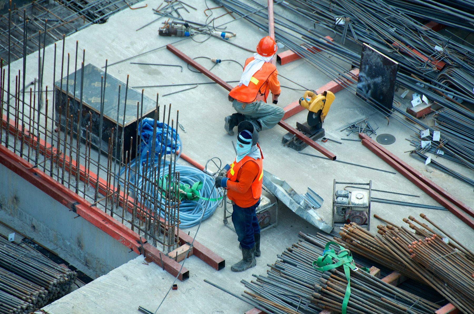 Crew working a rebar mat and formwork on a concrete slab pour